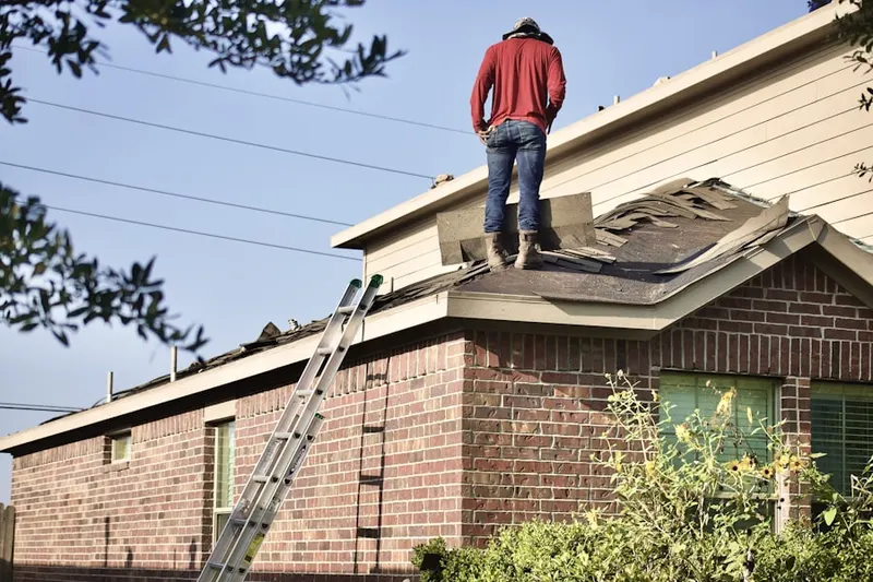 Professional roofer working on a residential roof in Herndons Mill